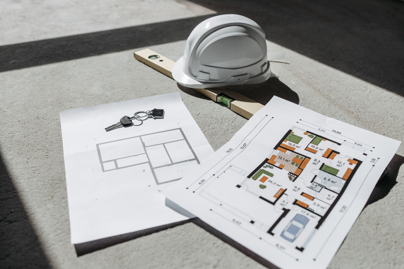 Construction blueprints and building permit documents with hard hat for Arizona survey checklist
