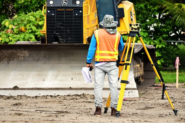 Surveyor using total station for construction staking at a building site in Arizona