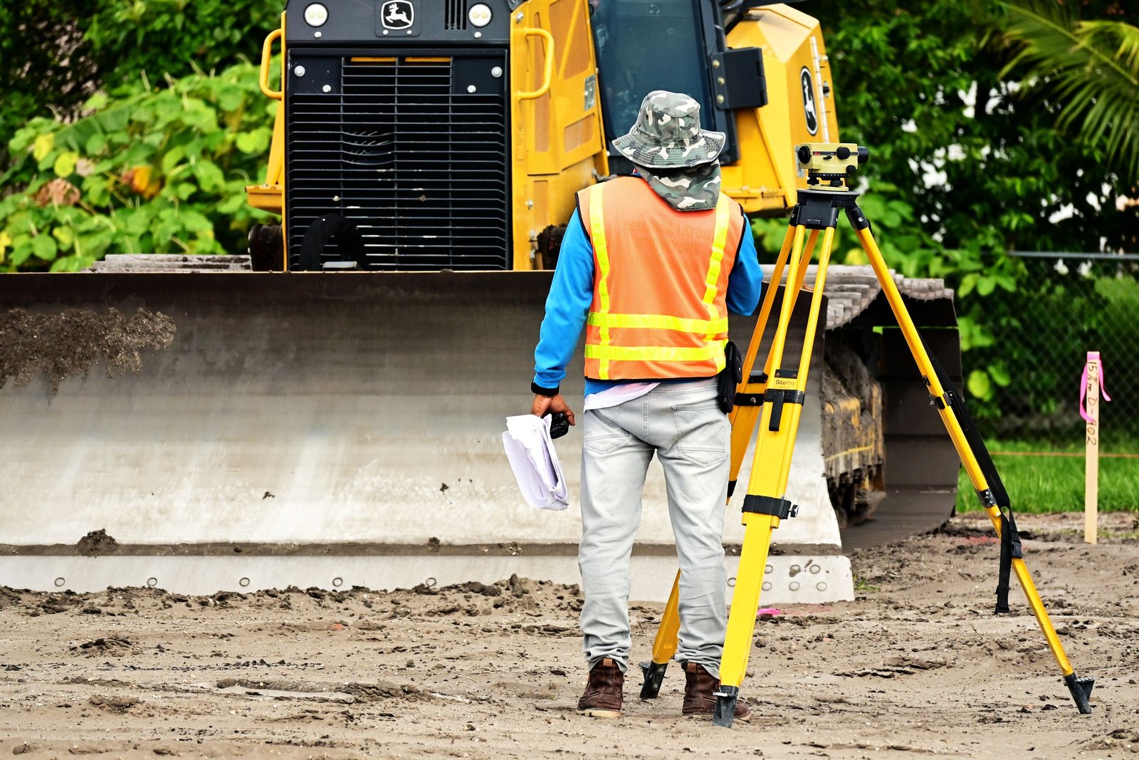 Surveyor using total station for construction staking at a building site in Arizona