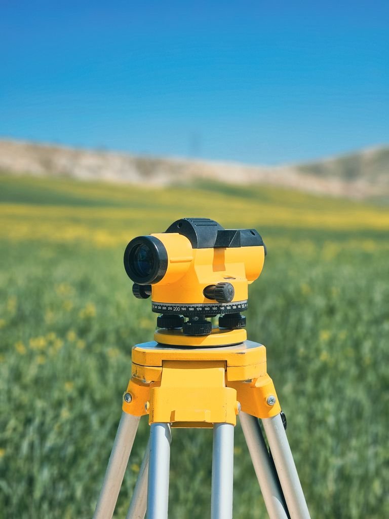 Yellow surveying level on tripod in Arizona landscape, land surveying equipment guide